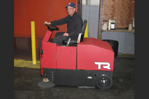 Using the TR floor sweeper to sweep up the dust and debris around warehouse racks and shelfs makes the job easier for everyone in the shop.